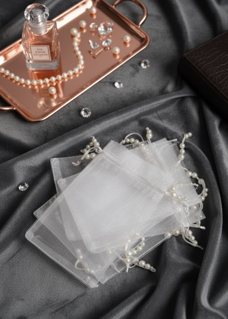 Set of clear jewelry display cards with decorative ribbons on a dark fabric background.