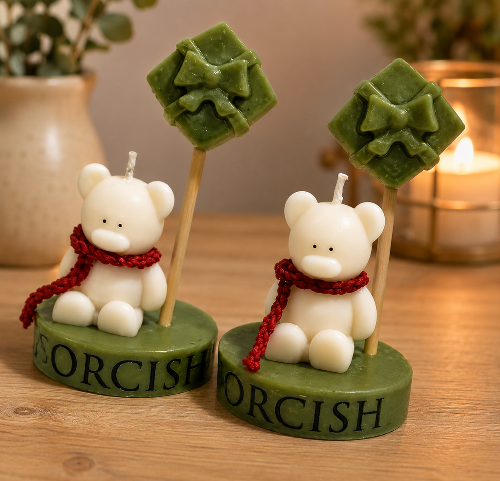 Two bear-shaped candles with green tops labeled 'Gorcish' on a wooden surface.
