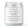 Candle jar with a motivational message label on a white background
