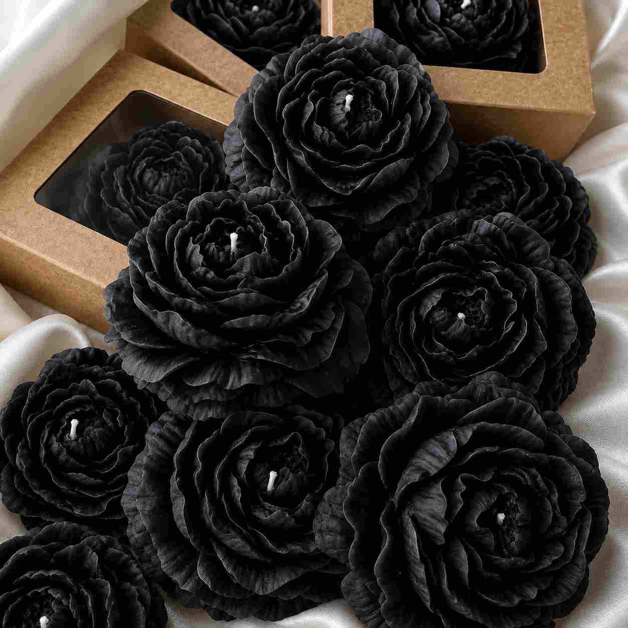 Black rose-shaped candles on a white fabric background
