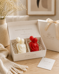 Two candles, one white and one red, in a 'Sorcish' branded box on a wooden surface.