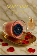Scented candle with a black flower design on a gold tray with red petals, next to a perfume bottle on a marble surface. Brand 'Sorcish' is visible.