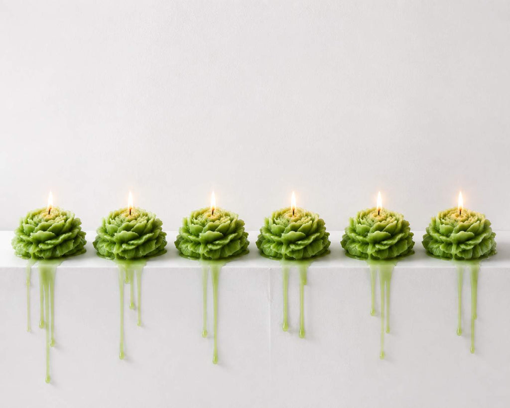 Row of green candles on a white surface with a light gray background