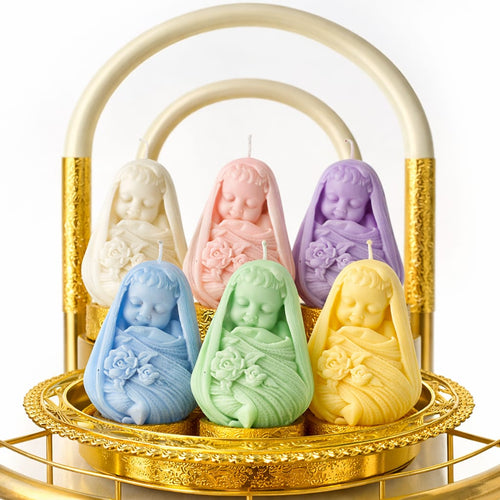 Set of pastel-colored baby-shaped candles in a decorative gold basket.