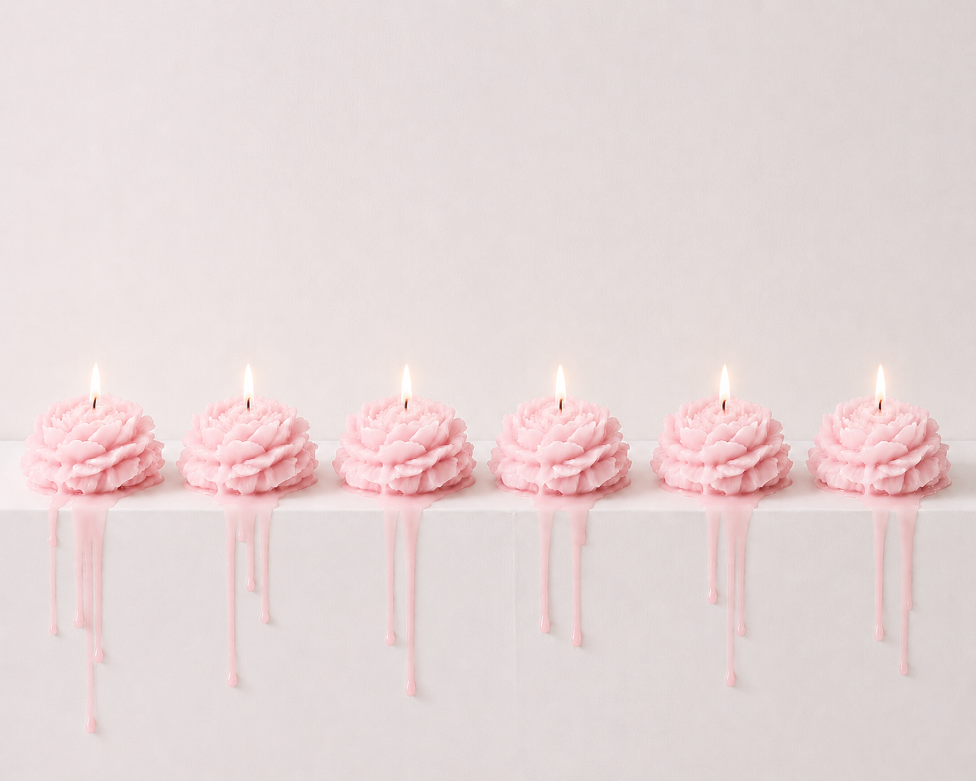 Six pink flower-shaped candles with dripping wax, arranged in a row on a white surface against a light pink background.