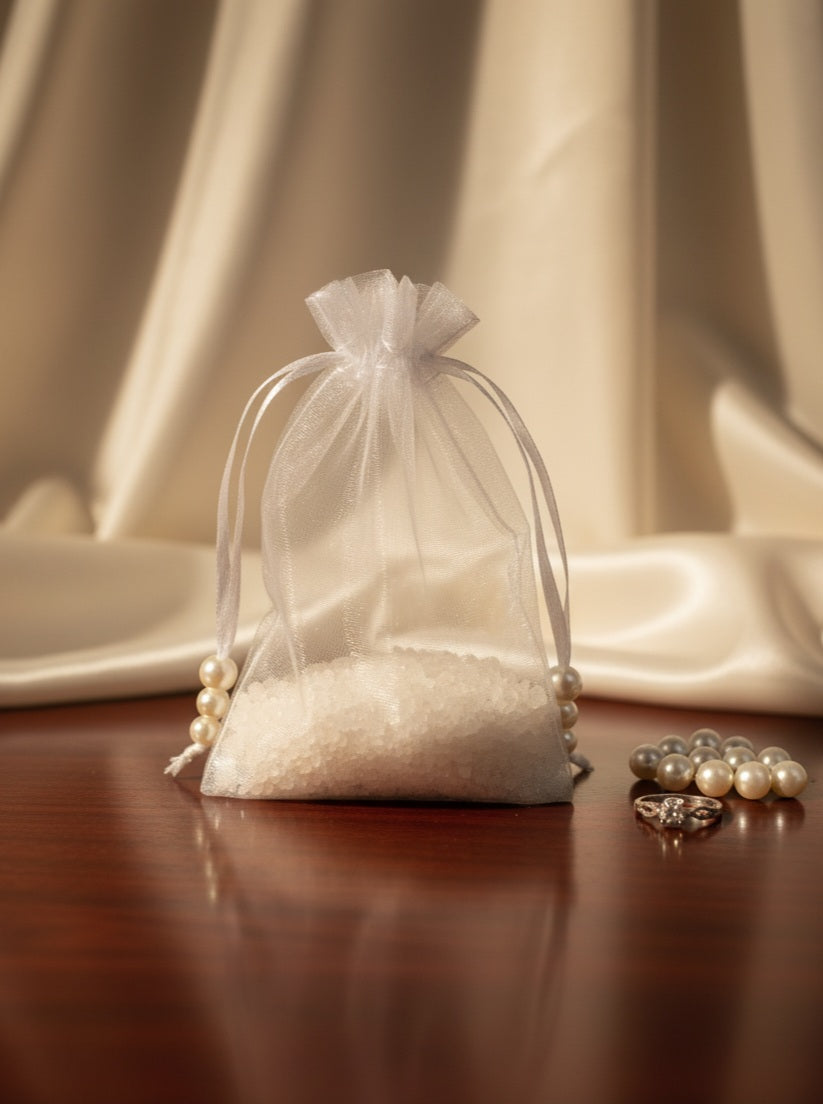 White organza bag with pearls on a wooden surface with a neutral background